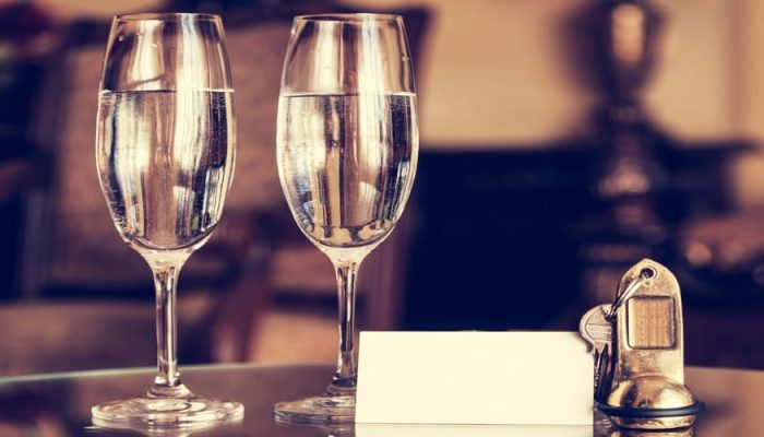 Full champagne glasses, antique keys and blank white card. Luxur